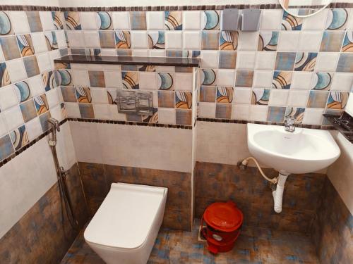 a bathroom with a toilet and a sink at The Whiteglow Elite in Chennai