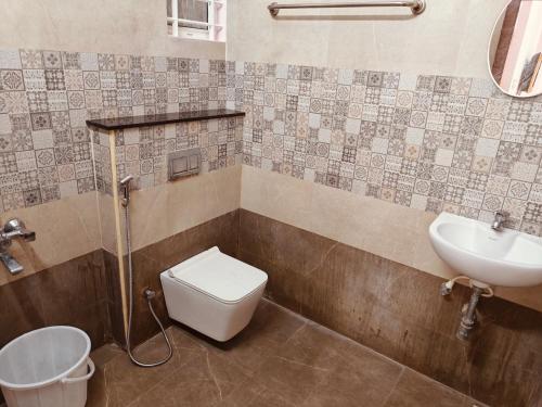 a bathroom with a toilet and a sink at The Whiteglow Elite in Chennai