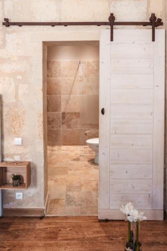 La salle de bains est pourvue d'une douche et d'une porte blanche. dans l'établissement logis-des-cordeliers, à Saint-Émilion