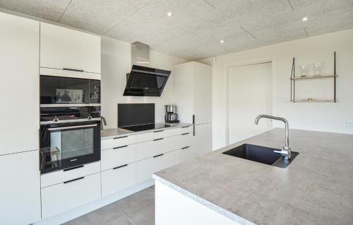 a kitchen with white cabinets and a sink in it at Cozy Home In Glesborg With Wifi in Glesborg