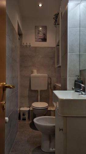 a small bathroom with a toilet and a sink at Portside Inn in Genova