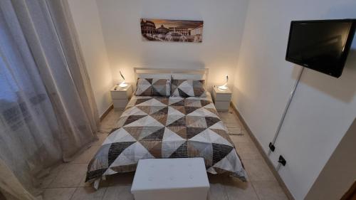 a small bedroom with a bed and a flat screen tv at Portside Inn in Genova