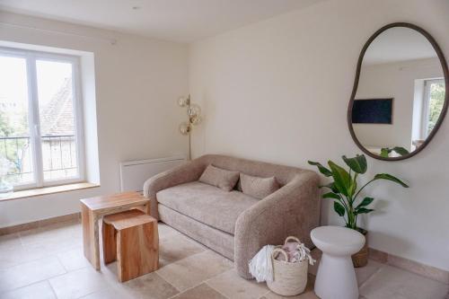 a living room with a couch and a mirror at Les Voiles Blanches - Appartement dans un château in Caen