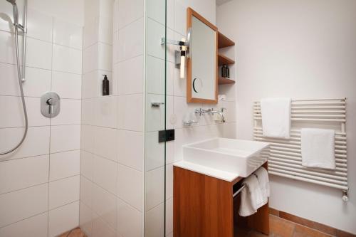 a bathroom with a sink and a shower at Alpina Lech - Geborgen in den Bergen in Lech am Arlberg