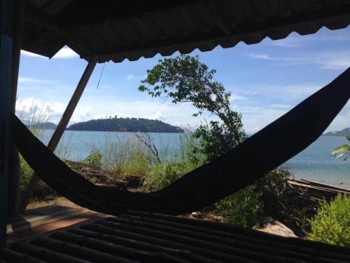a hammock with a view of a body of water at Tommys garden in Ranong