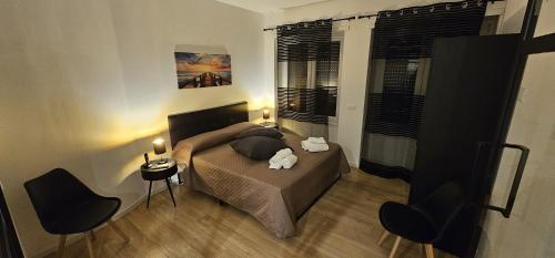 a bedroom with a bed and two chairs at Lux Beach Apartment BLACK in Lido di Ostia