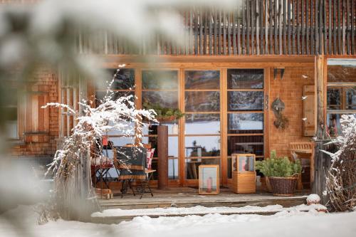 a house with a deck in the snow at Alpina Lech - Geborgen in den Bergen in Lech am Arlberg