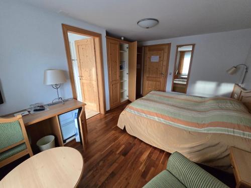 a bedroom with a bed and a desk and a chair at Haus Engel Gams in Gams