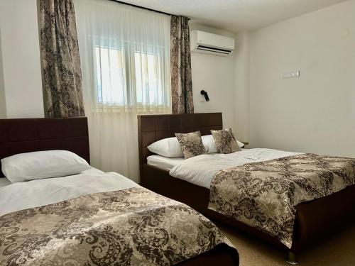 a hotel room with two beds and a window at Motel Marić in Žepče