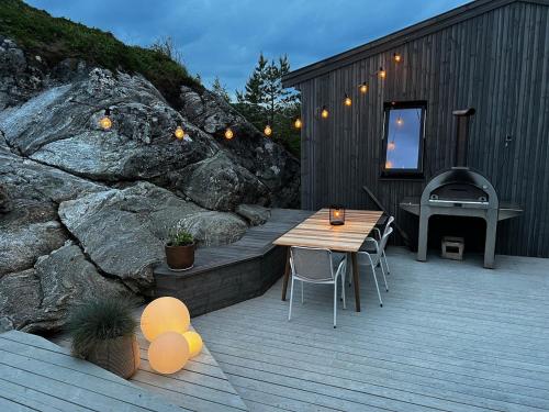 a wooden deck with a table and a piano at Great cottage with unique views and high standard in Tørhogg