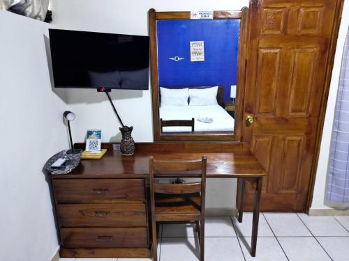 a desk with a mirror and a bed in a room at Hotel Sueños in San Salvador