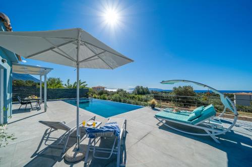 a patio with chairs and an umbrella and a pool at Fiora Villas in Trapezaki
