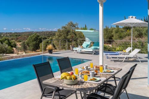 a table with fruit on it next to a pool at Fiora Villas in Trapezaki