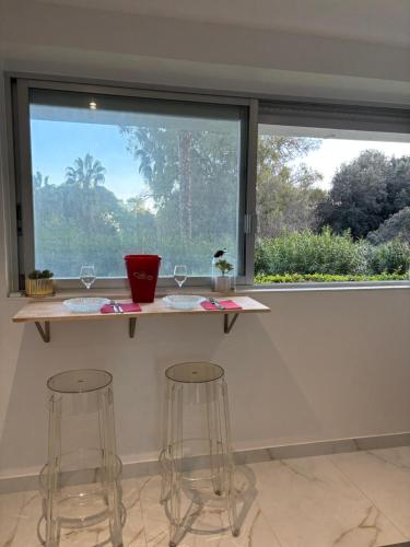 un comptoir avec deux tabourets devant une fenêtre dans l'établissement Studio Design mer, à Vallauris