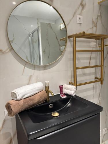une salle de bain avec un lavabo noir et un miroir dans l'établissement Studio Design mer, à Vallauris