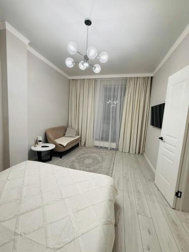 a white bedroom with a bed and a couch at Esil Riverside Elite Apartments in Astana