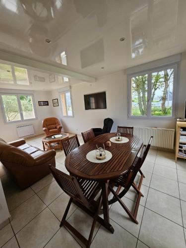 un salon avec une table et des chaises en bois dans l'établissement Villa des Oiseaux Lanvéoc Presqu'île de Crozon, à Lanvéoc