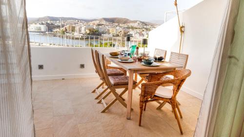 a dining room with a table and chairs and a window at Beachfront Haus Meer in the heart of Arguineguin in Arguineguín