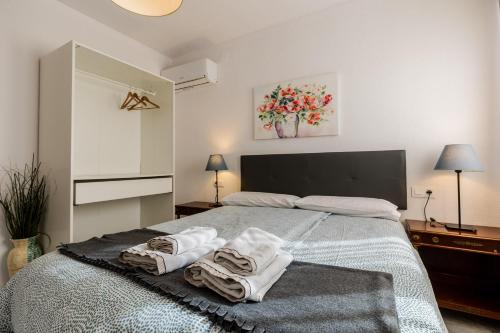 a bedroom with a bed with towels on it at Apartamentos Sendero del Veleta in Cenes de la Vega