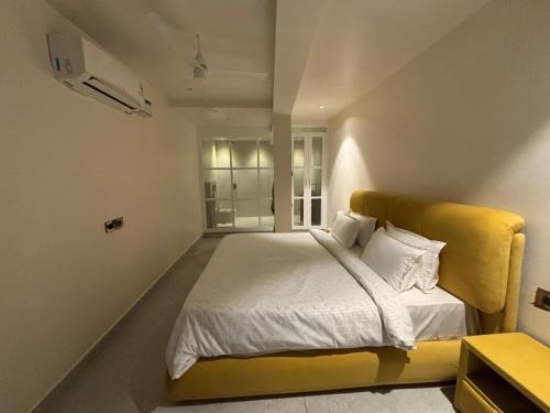 a bedroom with a large bed with a yellow headboard at Baga Beach Sea Salacia in Goa