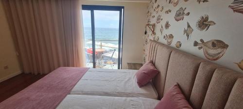 a bedroom with a bed with a view of the ocean at Casa Linda Baía in Porto da Cruz