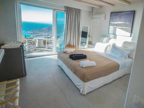 a bedroom with a large bed with a view of the ocean at White Rock Suites & Villas in Houlakia