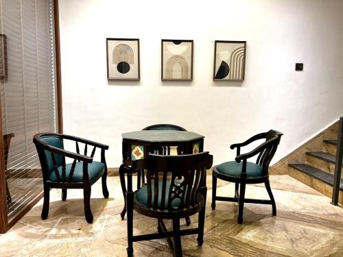two chairs and a table in front of a wall at Heartland- Ganga Villa with Jacuzzi and private lift in Rishīkesh