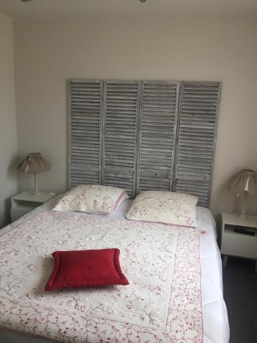 une chambre avec un grand lit avec un oreiller rouge dessus dans l'établissement Villa Heliomar, à Cavalaire-sur-Mer