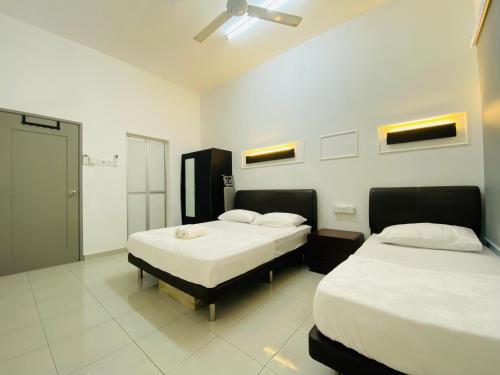 a bedroom with two beds and a ceiling fan at Alyn Home Batu Pahat VII Netflix Wifi Coway in Batu Pahat