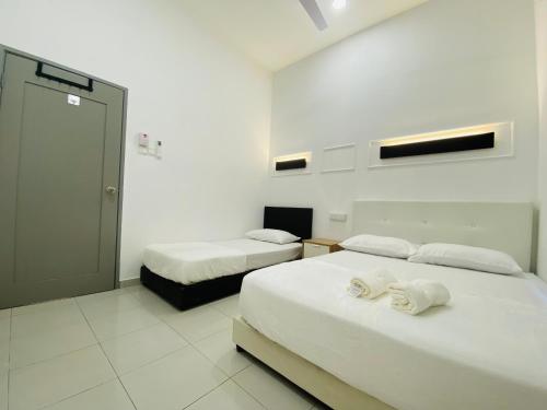 a room with two beds with towels on them at Alyn Home Batu Pahat VII Netflix Wifi Coway in Batu Pahat