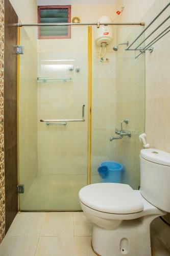 a bathroom with a toilet and a glass shower at HEAVEN PLEASANT STAy in Chennai
