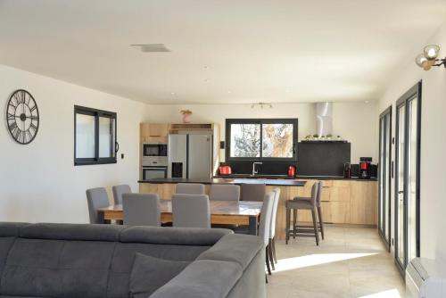 a kitchen and living room with a couch and a table at Maison avec vue et sa piscine chauffée privative in Bessas