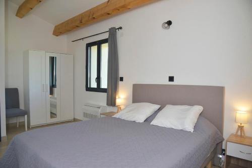 a bedroom with a large bed and a window at Maison avec vue et sa piscine chauffée privative in Bessas