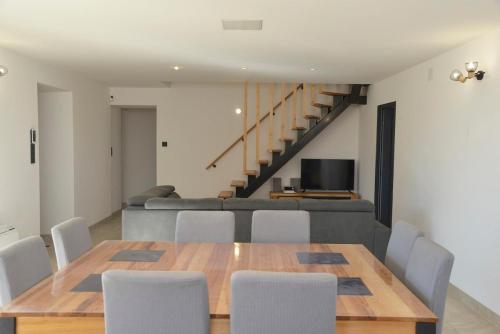 a dining room with a table and chairs and a couch at Maison avec vue et sa piscine chauffée privative in Bessas