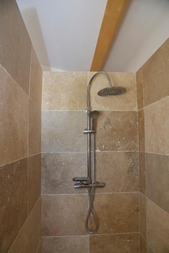 a shower with a shower head in a bathroom at Maison avec vue et sa piscine chauffée privative in Bessas