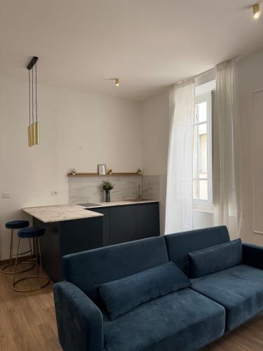 a living room with a blue couch and a kitchen at Gli Occhi di Carolina - Palazzo Carolina in Pescara