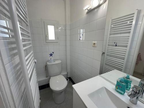 une salle de bain blanche avec des toilettes et un lavabo dans l'établissement Le Saint-Mathieu, à Nîmes