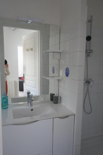une salle de bain blanche avec un lavabo et un miroir dans l'établissement Le Saint-Mathieu, à Nîmes