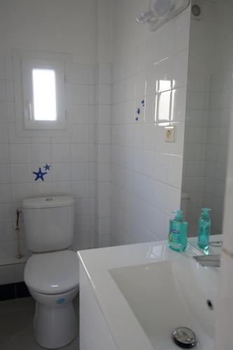 une salle de bain blanche avec des toilettes et un lavabo dans l'établissement Le Saint-Mathieu, à Nîmes