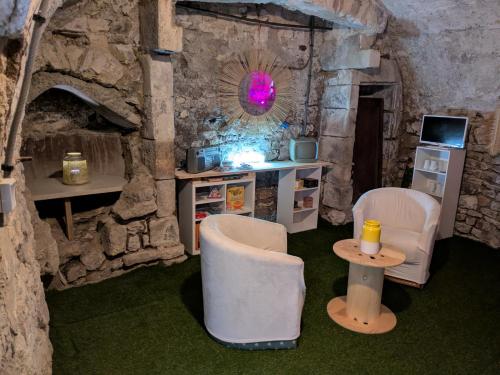 ein Raum mit zwei Stühlen und einem Tisch in einer Höhle in der Unterkunft Evasion vintage in La Sauvetat