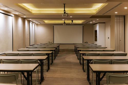 an empty lecture room with tables and a whiteboard at Grand Sirenis Riviera Maya Resort & Spa All Inclusive in Akumal