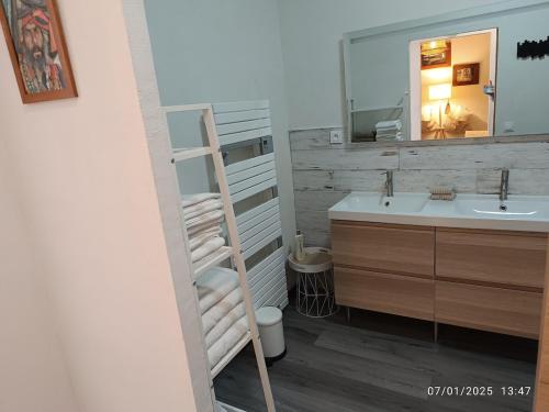 La salle de bains est pourvue d'une échelle, d'un lavabo et d'un miroir. dans l'établissement Bormes Village appartement 2 chambres, à Bormes-les-Mimosas