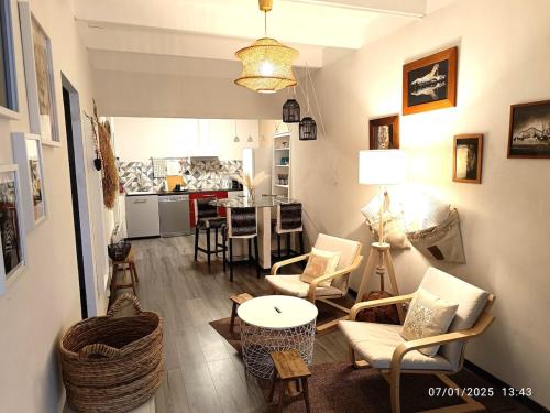 un salon avec une table et des chaises et une cuisine dans l'établissement Bormes Village appartement 2 chambres, à Bormes-les-Mimosas