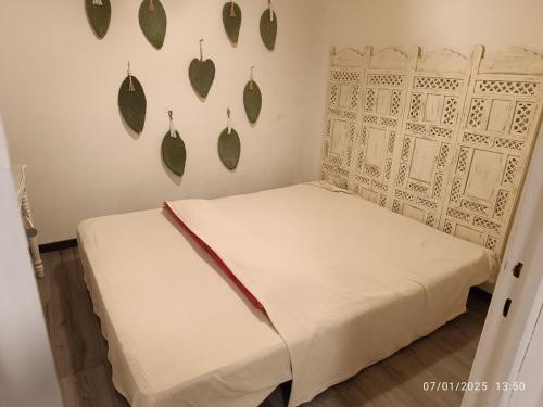 - un lit dans un dortoir avec des feuilles sur le mur dans l'établissement Bormes Village appartement 2 chambres, à Bormes-les-Mimosas