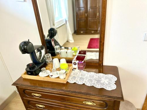 a dresser with a mirror and a table with dishes at Quarto Eixo Atlântico in Bragança