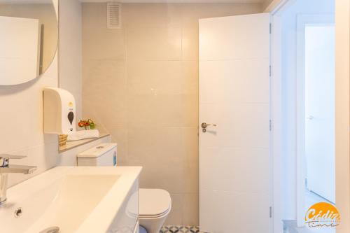 a bathroom with a white tub and a toilet at Retama Golf by Cadiz Time in Novo Sancti Petri