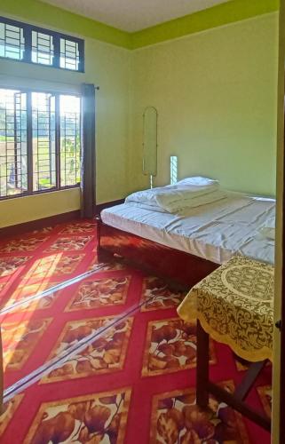 a bedroom with a bed and a table in it at Holiday Home Stay in Sivasagar