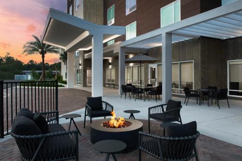 a patio with chairs and a fire pit in front of a building at TownePlace Suites By Marriott Lake City in Lake City
