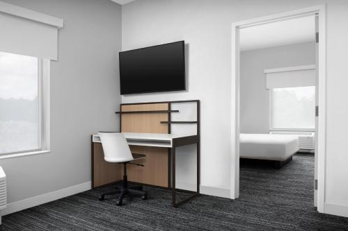 a room with a desk and a tv and a chair at TownePlace Suites By Marriott Lake City in Lake City