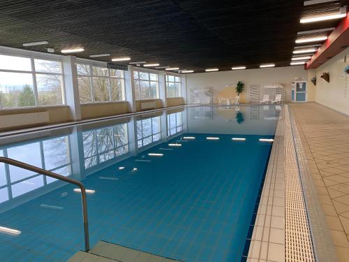 a large indoor swimming pool with blue water at Panoramic - Wanderlust #329 mit Schwimmbad in Hohegeiß